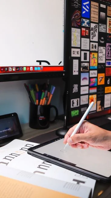 Un homme consulte les actualités sur une tablette tout en savourant un café, stylet à la main.